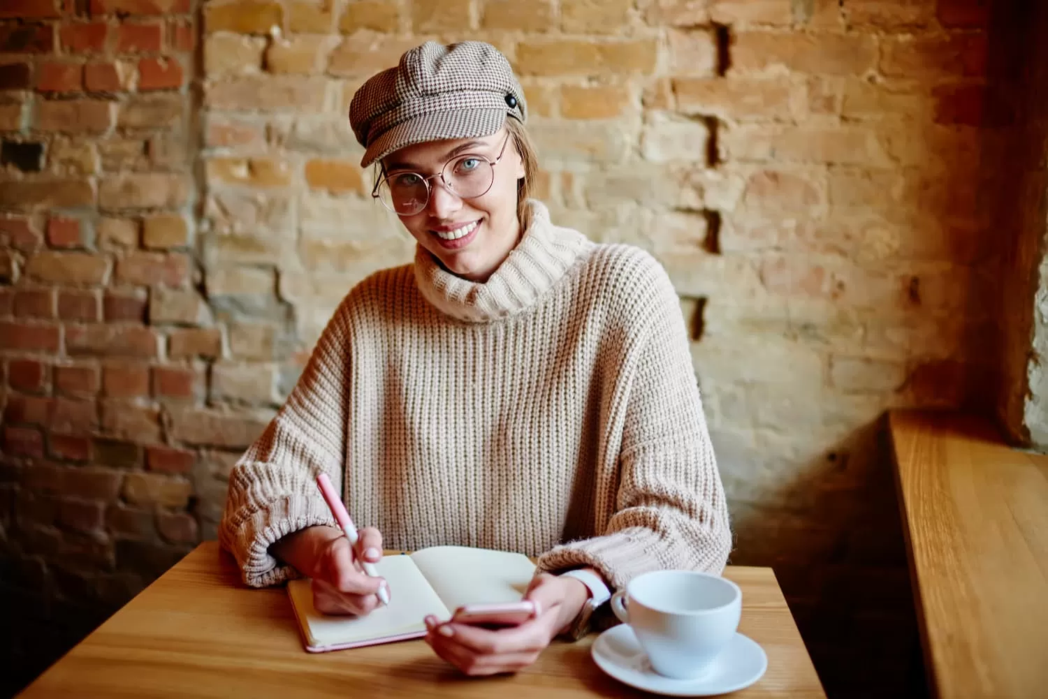 chica sonriente con el pelo recogido escribe en un libro