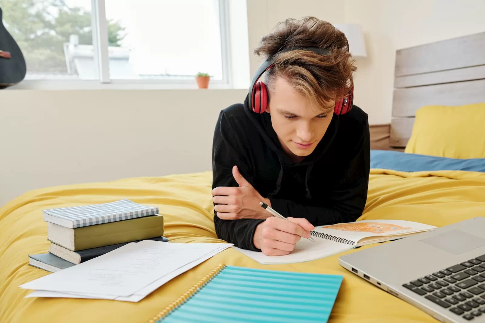 estudiante bachiller realizando las tareas sobre la cama