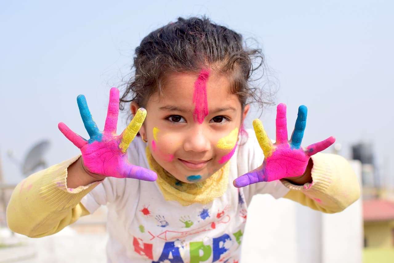 Niña pequeña con pintura en las manos
