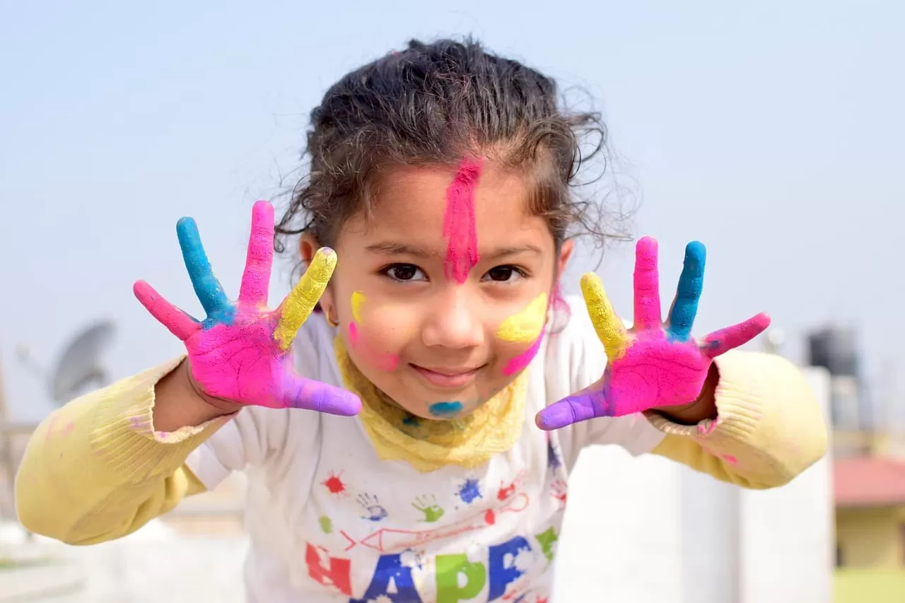 Niña pequeña con pintura en las manos