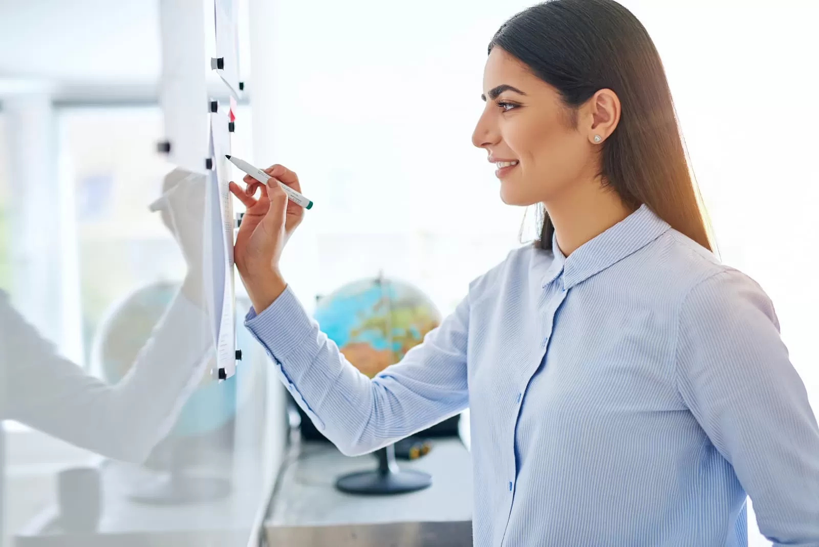 profesora en pizarra resolviendo ejercicio
