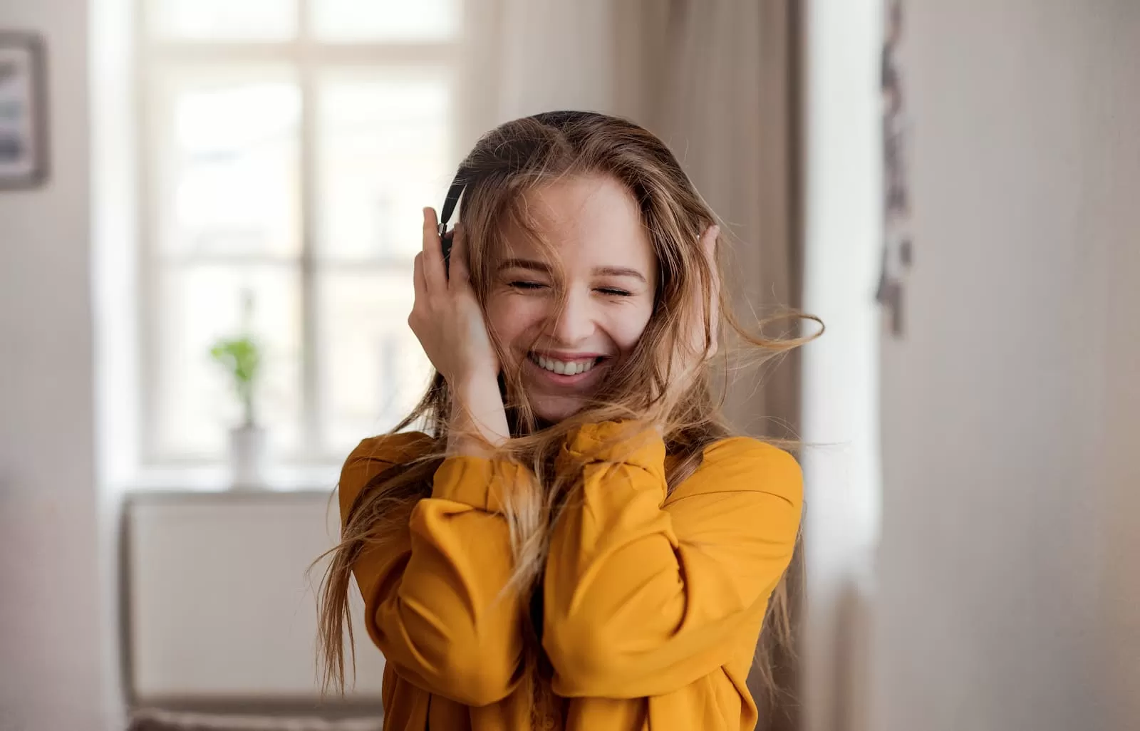 una joven estudiante rubia con cascos sonrie