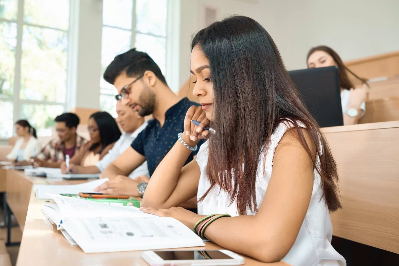 vista lateral de joven estudiante que se prepara para examen uned